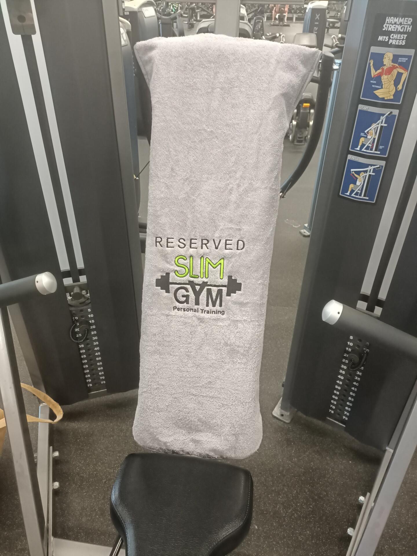 Hooded Towel Draped Over Chest Press Machine for Personal Space Reservation